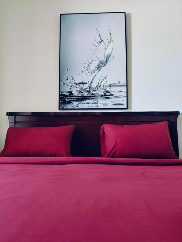 a bedroom with a red bed with two red pillows at Sea View Studio 4 Royal Breeze Breezeسي ويو ستوديو رويال بريز in Ras al Khaimah