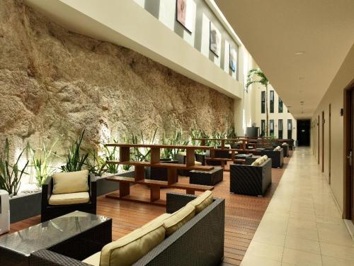 a lobby with couches and tables and a stone wall at Sol de Cabo in San José del Cabo