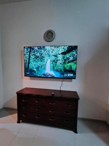 a flat screen tv sitting on top of a dresser at Sea View Studio 4 Royal Breeze Breezeسي ويو ستوديو رويال بريز in Ras al Khaimah