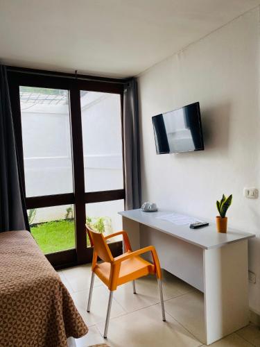 a bedroom with a desk and a chair and a tv at Casa San Juan 560 in Managua