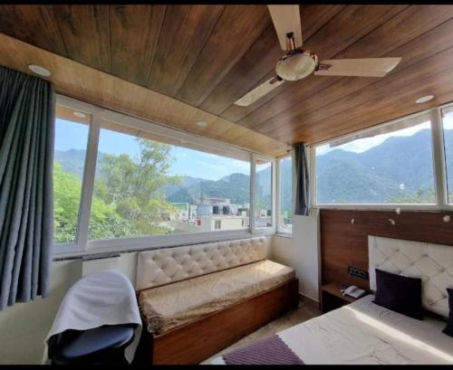 NarendranagarHotel Mount view的卧室设有大窗户、一张床和一把椅子