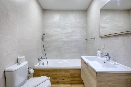 a bathroom with a tub and a toilet and a sink at Unique two bedroom apt with huge outdoor area and close to entertainment in Is-Swieqi