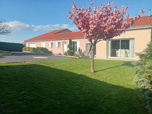a tree in a yard in front of a house at Maison a la campagne in Valprivas