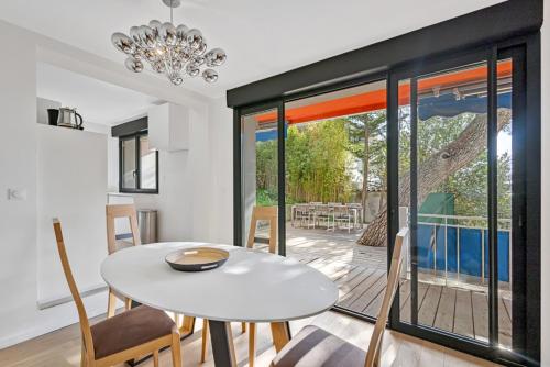 une salle à manger avec une table et des chaises blanches dans l'établissement Cassis, superbe appartement avec terrasse, à Cassis