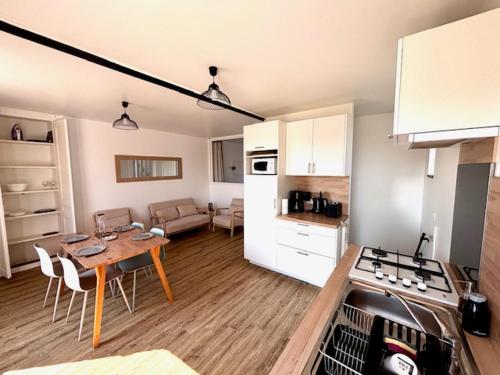 Il comprend une cuisine et un salon avec une table. dans l'établissement Duplex, terrasse, vue mer, 30m plage, à Port-Bail-sur-Mer