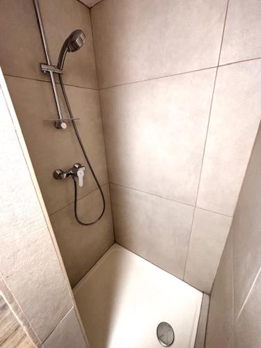 une douche avec pommeau de douche dans une salle de bain dans l'établissement Duplex, terrasse, vue mer, 30m plage, à Port-Bail-sur-Mer