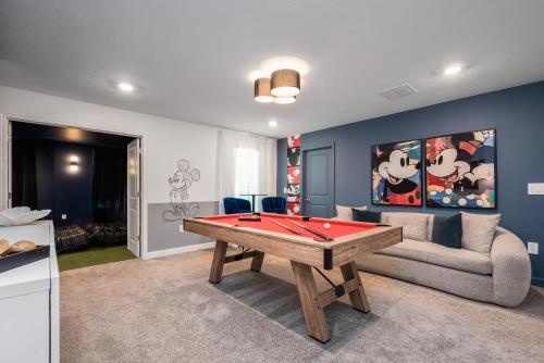 a living room with a pool table and a couch at Luxury 9BR Gem- Heated Pool, Theater & Theme Rooms in Kissimmee
