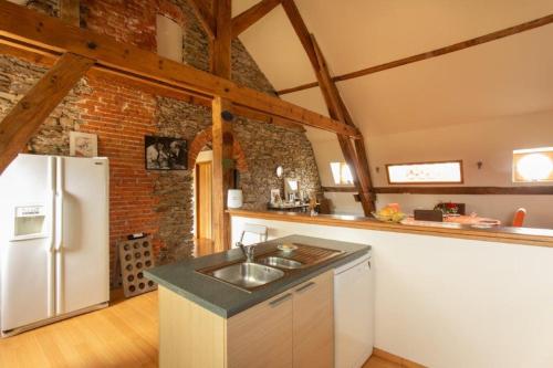 a kitchen with a sink and a white refrigerator at CHATEAU du PERRAY in Saint-Mars-du-Désert
