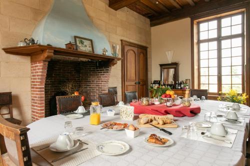 a dining room with a table with food on it at CHATEAU du PERRAY in Saint-Mars-du-Désert