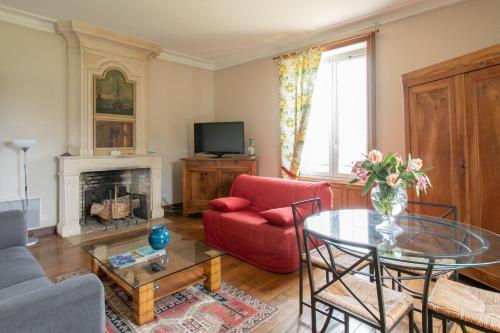 a living room with a red couch and a table at CHATEAU du PERRAY in Saint-Mars-du-Désert