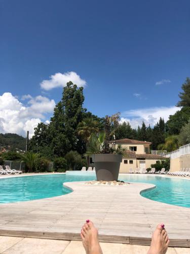 une personne avec les pieds sur une promenade à côté d'une piscine dans l'établissement Cottage 4 à 6 p SollieToucas , climatisé, piscine, vue, terrasse, à 0,400m du centre, à Solliès-Toucas