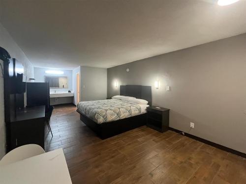 a bedroom with a bed and a desk in a room at Studio 6 Suites Hurricane, WV in Hurricane