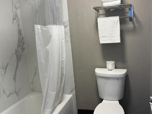 a bathroom with a white toilet and a shower at Studio 6 Suites Hurricane, WV in Hurricane