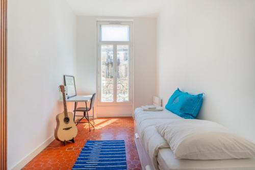 - une chambre avec un lit, une guitare et un bureau dans l'établissement Le Palais Longchamp, appart lumineux emplacement idéal, à Marseille