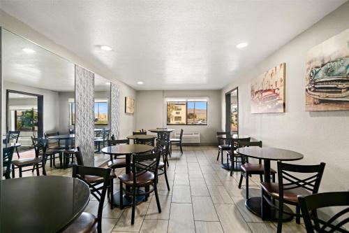 un restaurant avec des tables et des chaises dans une salle dans l'établissement Best Western Desert Villa Inn, à Barstow