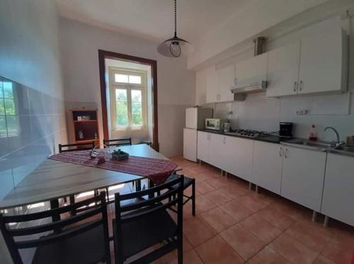 a kitchen with a table and a table and chairs at António Augusto Apartment in Coimbra