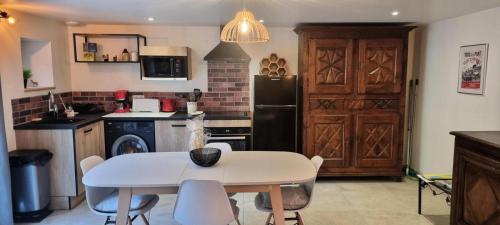 a kitchen with a table and chairs and a refrigerator at Gîte de France Gîte le petit air 3 épis - Gîte de France 3 personnes MAE-6624 in Argentat