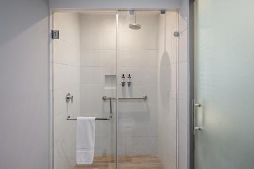 une salle de bain avec une douche avec une porte vitrée dans l'établissement Gamma Toluca, à Toluca