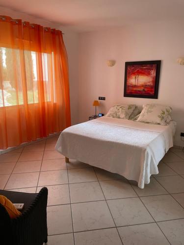 - une chambre avec un grand lit et un rideau orange dans l'établissement Ghiso, à Ghisonaccia