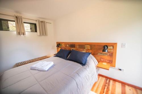 a bedroom with a large bed with blue pillows at Suíte jasmim vermelho in Campos do Jordão