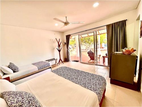a bedroom with two beds and a large window at Hotel Carey Beach Baru in Baru