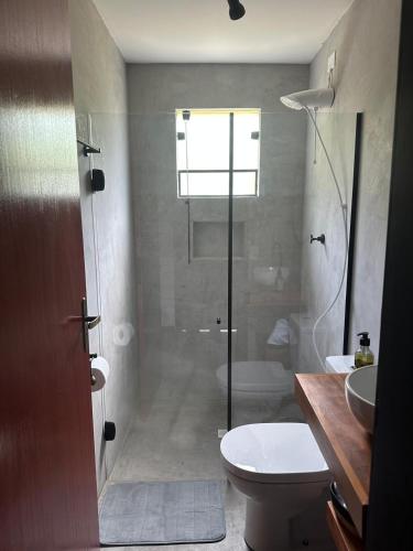 a bathroom with a shower and a toilet and a sink at Suíte jasmim vermelho in Campos do Jordão