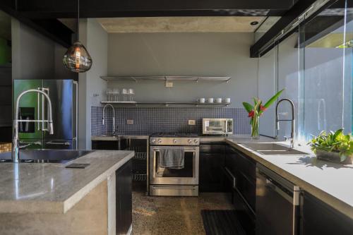 a kitchen with a stove and a sink at Entre Lomas Boutique in Montezuma