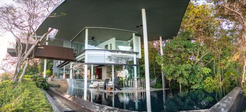 a house with a glass facade on the water at Entre Lomas Boutique in Montezuma