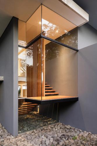 a house with a glass facade with stairs at Entre Lomas Boutique in Montezuma