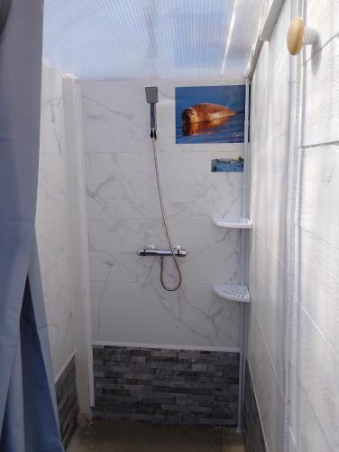une douche avec un tuyau dans une salle de bain dans l'établissement tente en baie de somme chez l habitant, à Cayeux-sur-Mer
