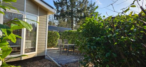 a patio with a table and chairs next to a house at De Kleine Kriemelkuil - Het Vosje in Ermelo