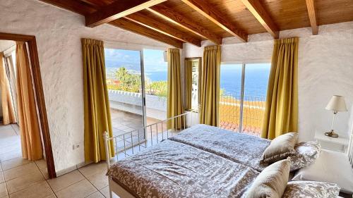 Un dormitorio con una cama y vista al mar. en Residencial Rolando, en La Matanza de Acentejo