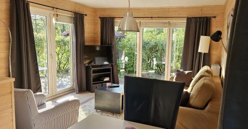 a living room with a couch and a tv at De Kleine Kriemelkuil - Het Vosje in Ermelo