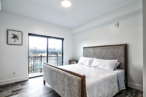 a bedroom with a large bed and a balcony at Cozy Luxury Close to Downtown 204 in Juneau