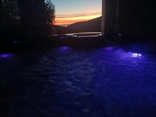 una vista notturna di una vasca idromassaggio con luci viola di Agriturismo Orto dei Rolli a Moneglia