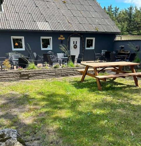 a picnic table in front of a blue house at Meerblick Cafe Reiten Spielplätze Animation WLAN in Fanø