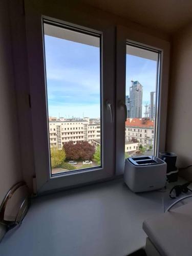 a room with two windows and a printer on a desk at Mieszkanie w samym sercu Gdyni, 3 minuty od plaży. in Gdynia