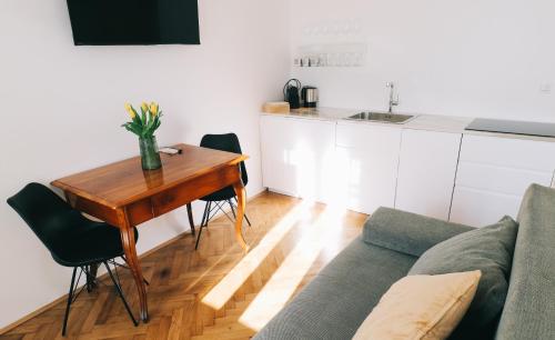 a living room with a table and a couch at Central Riverside Apartments Meščanka in Ljubljana
