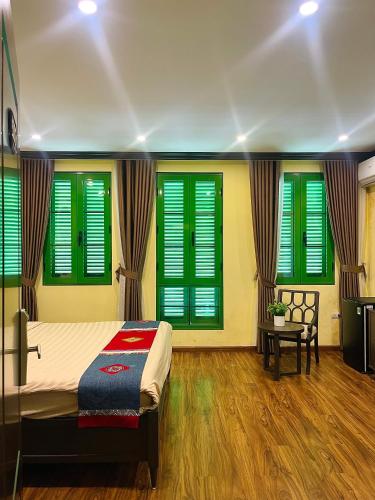 a bedroom with green shuttered windows and a bed at Moonlight Hotel Sa Pa in Sa Pa