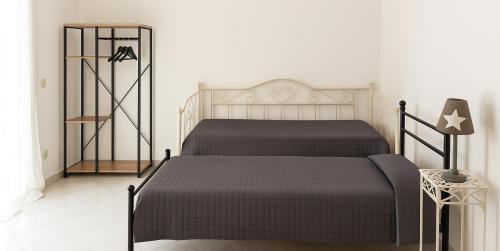 a bedroom with two beds and a table with a lamp at White House in Sassari