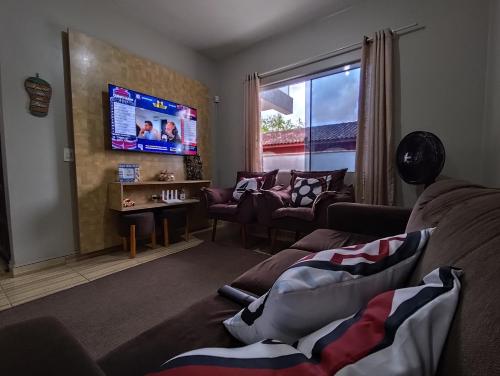 a living room with a couch and a flat screen tv at Sobrado Lar Doce Mar Itapoá 100m from the Sea in Itapoa