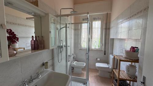 a bathroom with a shower and a sink and a toilet at Versilia Apartment with Garden in Montignoso