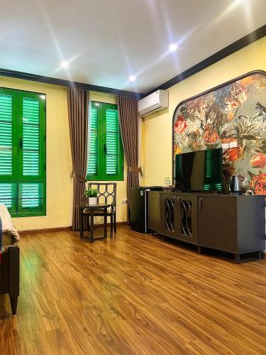 a living room with green shuttered windows and a flat screen tv at Moonlight Hotel Sa Pa in Sa Pa