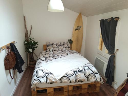 - une chambre avec un lit et une planche de surf dans l'établissement La cabane 1949, à Gujan-Mestras