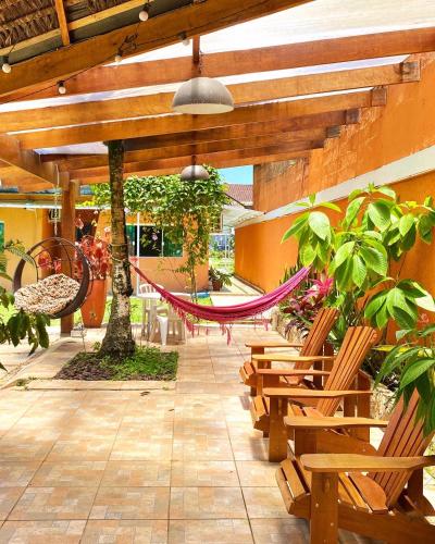a patio with benches and hammocks in a building at Pousada Dolce Vita in Itanhaém