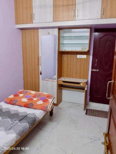 a small room with a bed and a desk at Sree Paradise Homestay in Tiruvannāmalai