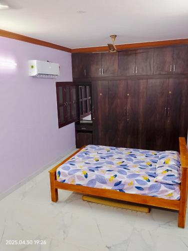 a bedroom with a bed and wooden cabinets at Sree Paradise Homestay in Tiruvannāmalai