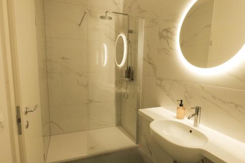 a bathroom with a shower and a sink and a mirror at Central Riverside Apartments Meščanka in Ljubljana