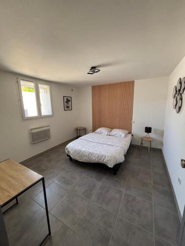 a bedroom with a bed and a table in it at UNIQUE villa Zen et Détente avec piscine très bien placé proche du centre in Montpellier
