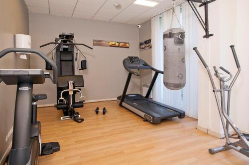 a gym with a treadmill and exercise equipment in a room at Séjours & Affaires Courbevoie Grande Arche in Courbevoie